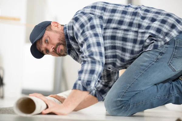 Uomo Posa Rotolo Tappeto Sul Pavimento — Foto Stock