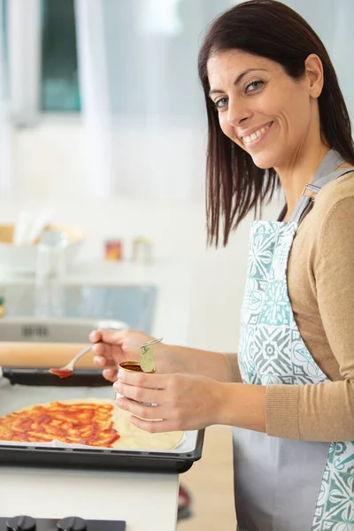 Mujer Añadiendo Salsa Tomate Pizza —  Fotos de Stock