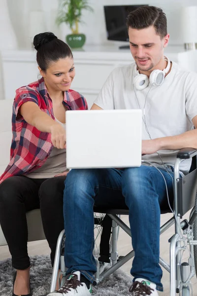 Homem Com Laptop Cadeira Rodas Com Mulher Mostrando Lhe Algo — Fotografia de Stock