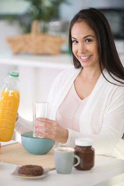 一个女人倒入橙汁当早餐的肖像 — 图库照片
