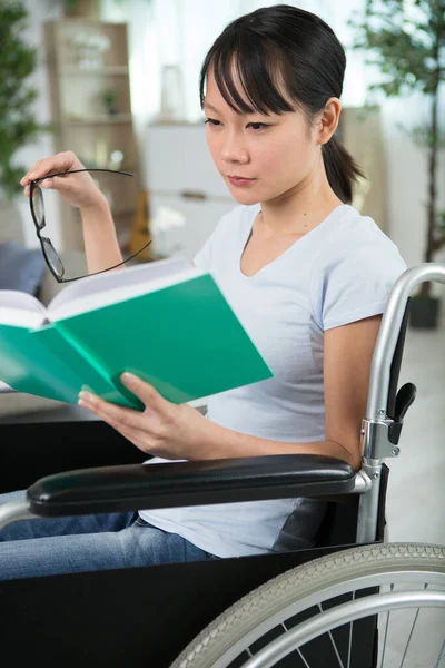 本で車椅子で幸せな障害のある女性 — ストック写真