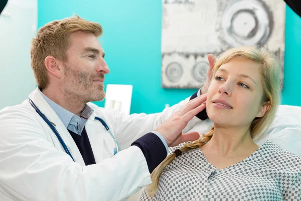 doctor examining female patients ear