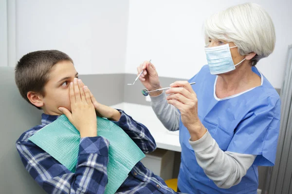 Αγόρι Κρύβει Στόμα Του Πίσω Από Χέρια Στον Οδοντίατρο — Φωτογραφία Αρχείου