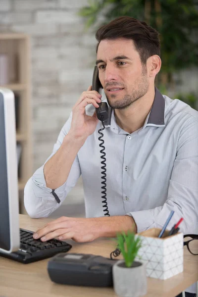 Hombre Sentado Escritorio Hablando Por Teléfono Fijo —  Fotos de Stock