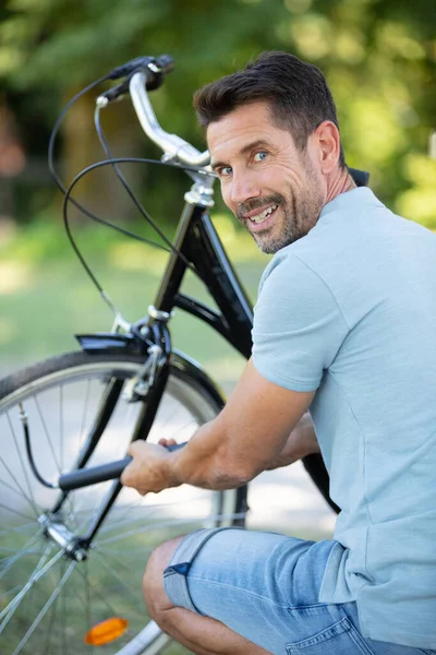 Hombre Mirando Sobre Hombro Mientras Inflando Neumático Bicicleta — Foto de Stock