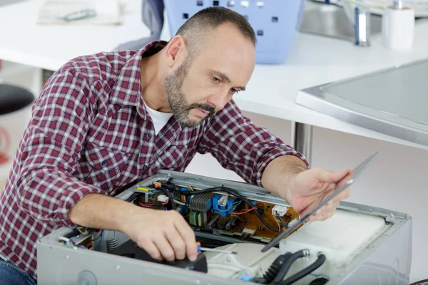Serviceman Zoek Naar Tablet Tijdens Het Repareren Van Wasmachine — Stockfoto