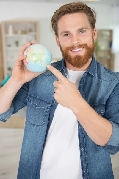 Smiling Man Holding Globe Searching Locations — ストック写真