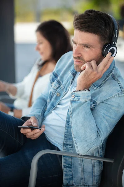 Homem Sentado Plataforma Estação Trem Com Fone Ouvido — Fotografia de Stock