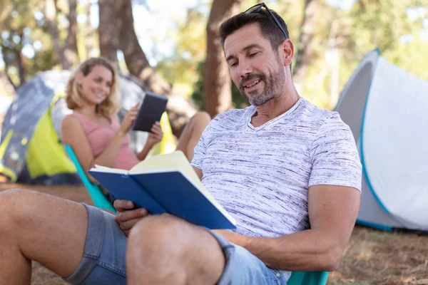 Camping Man Czyta Książkę Podróżujących Gildii Obozie — Zdjęcie stockowe