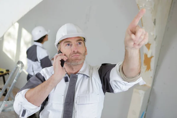 Bouwer Telefoon Wijzen Naar Binnen — Stockfoto