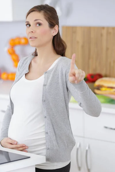 Zwangere Vrouw Met Wit Sweatshirt Wijst Naar Iets — Stockfoto