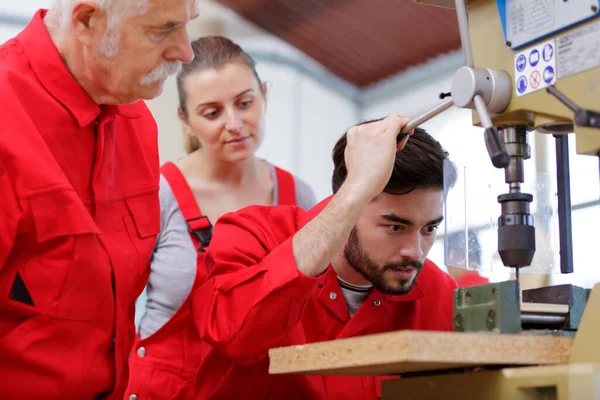 Apprentice Drilling Hole Using Machine — стоковое фото