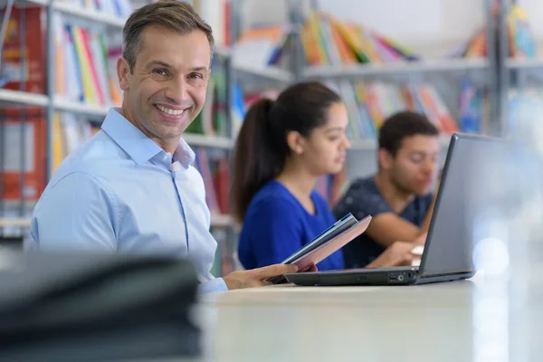 Homem Sorridente Estudando Com Computador Portátil Mesa Biblioteca — Fotografia de Stock