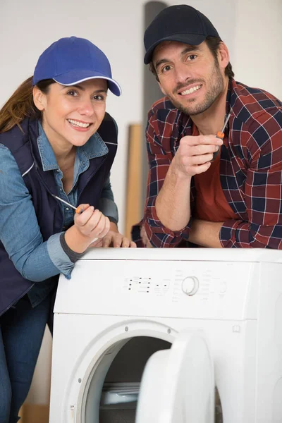 Glückliches Paar Von Auftragnehmern Die Waschmaschine Reparieren — Stockfoto