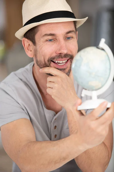 Man Holding Small Globe While Sitting Sofa Home — Stock Photo, Image
