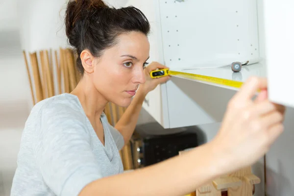 Woman Measuring Cupboard — Stock Photo, Image