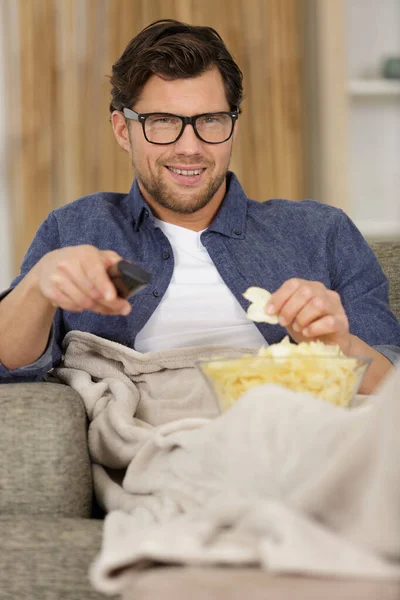 Man Blanket Sofa Eating Snacks Watching — ストック写真