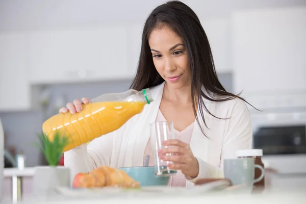 Beautiful Young Woman Pouring Orange Juice Glass — стоковое фото