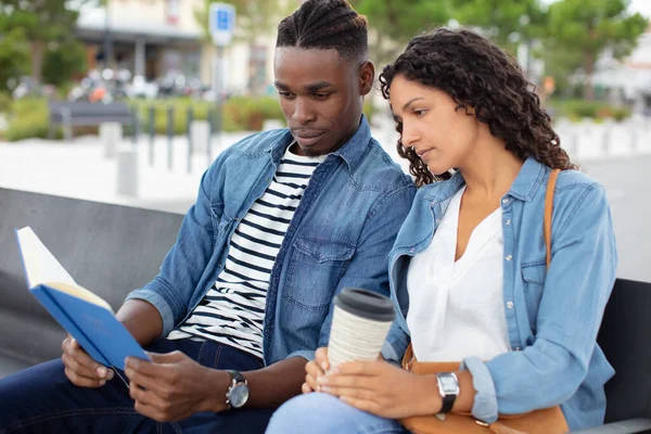 Paar Buiten Bank Kijken Naar Boek Samen — Stockfoto