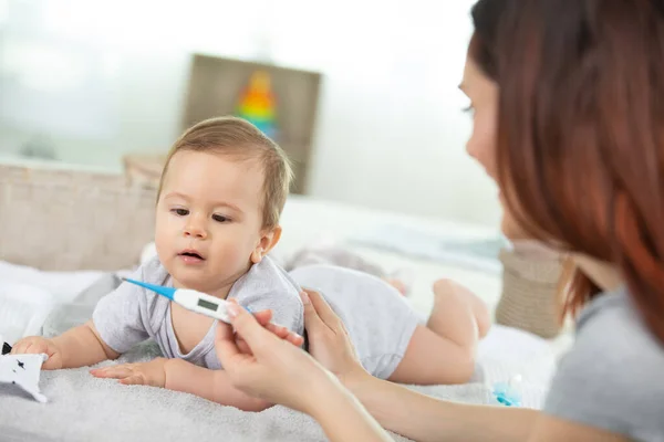 Mãe Verificando Termômetro Segurando Seu Bebê Doente Casa — Fotografia de Stock