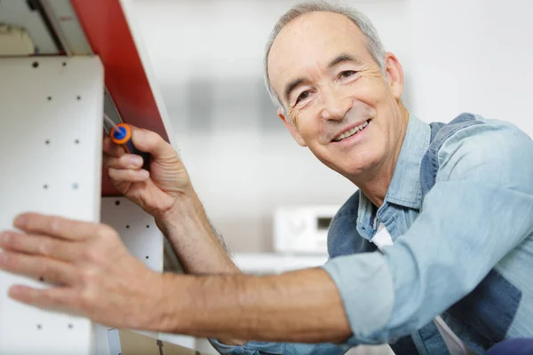 Senior Man Assembles Furniture — Stock Photo, Image