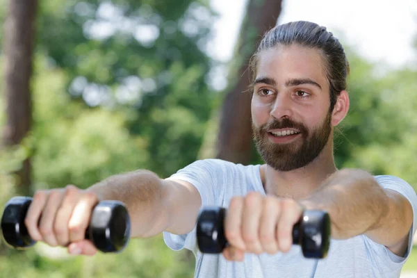 Sportlicher Junger Mann Trainiert Mit Kurzhanteln Park — Stockfoto