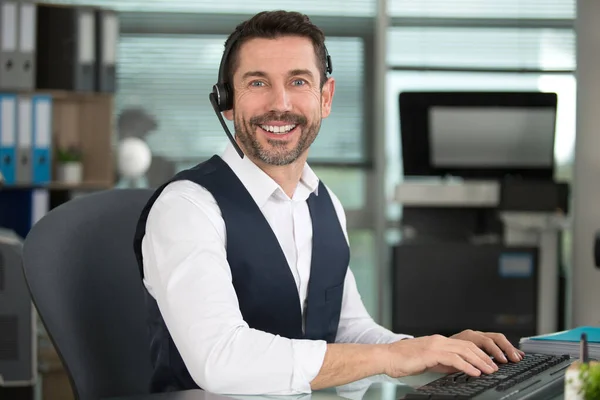 Lächelnder Kundenbetreuer Mit Freisprecheinrichtung — Stockfoto