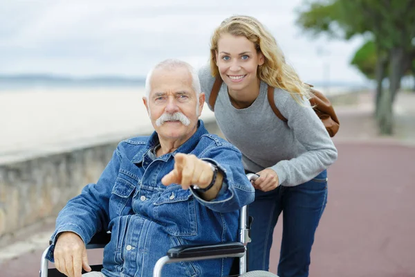 娘と一緒に公園で車椅子の年配の男性 — ストック写真