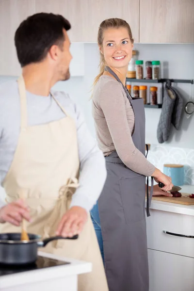 在厨房里微笑的年轻夫妇在做饭 — 图库照片