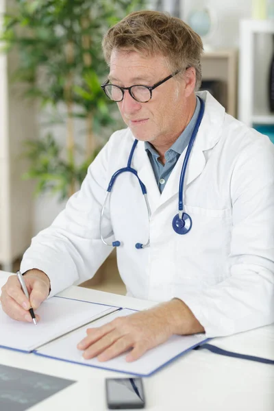 Senior Doctor Writing Notes — Stockfoto