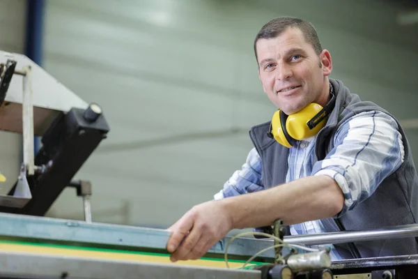 portrait of male engineer with cad drawings in factory