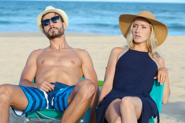 男人和女人坐在海滩上 — 图库照片