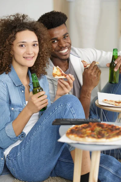 Couple Sat Floor Eating Pizza Drinking Beer — Stock fotografie