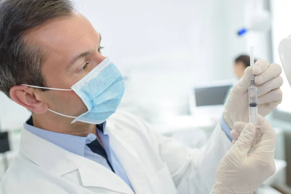 Masked Male Doctor Removing Protective Sheath Syringe — Stok fotoğraf