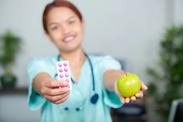 Femme Médecin Montrant Des Comprimés Une Pomme — Photo