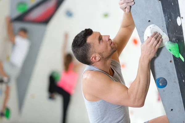 Man Climbing Artificial Boulders Wall Indoor — Stockfoto