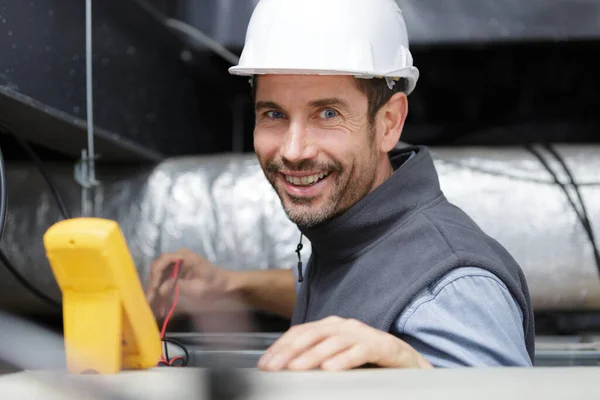 Happy Repairman Repairing Measuring Voltage Ceiling — Stockfoto
