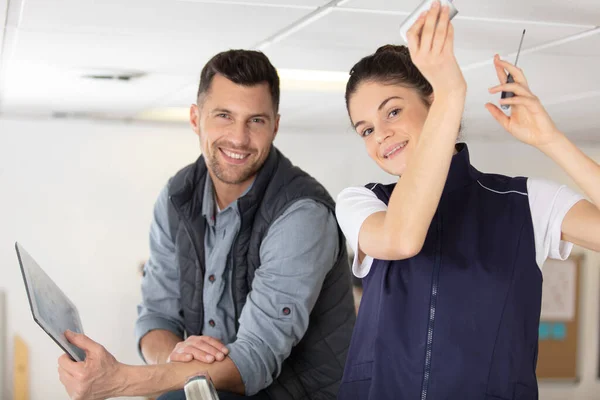 Glad Kvinnlig Elektriker Montera Kabel För Takljus — Stockfoto