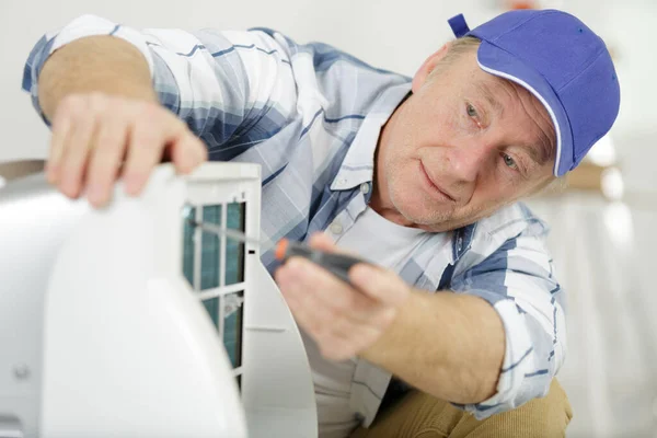 Starszy Mężczyzna Używający Śrubokrętu Urządzeniu Elektrycznym — Zdjęcie stockowe