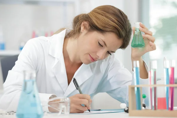 Scienziata Donna Che Tiene Mano Fiaschetta Vetro Prende Appunti — Foto Stock