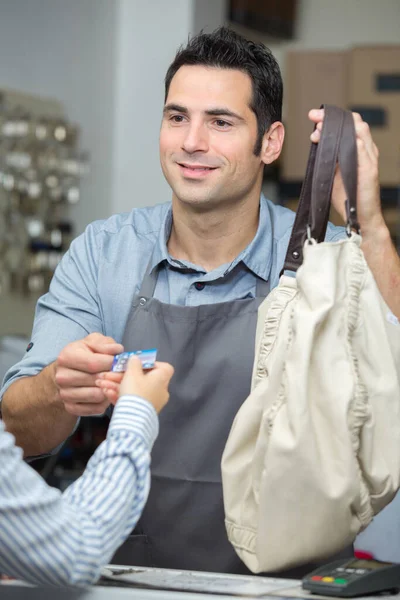 Male Clerk Taking Payment Shop Counter — Stock Fotó