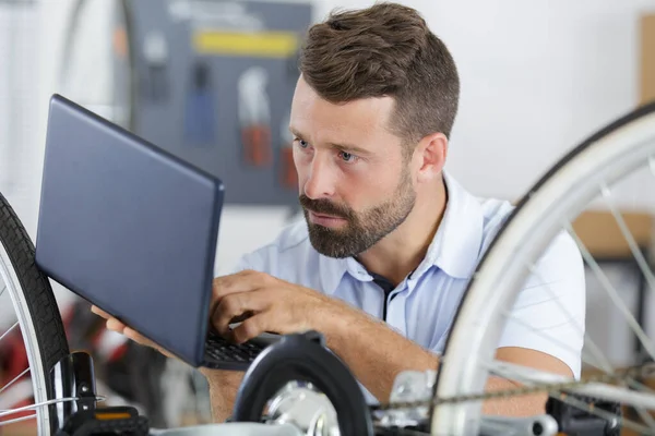 Young Man Repairing Bicycle Help Laptop — Stock Fotó