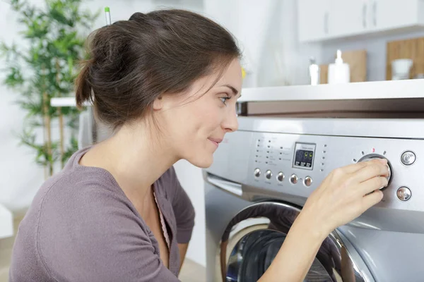 女人在洗衣机装上脏衣服后 — 图库照片