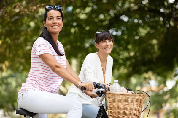 Two Female Friends Riding Bicycles Park — Stockfoto