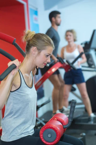 Young Woman Exercising Back Machine Gym — 스톡 사진