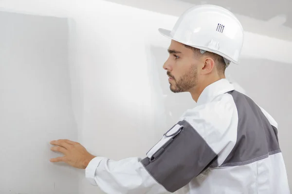 Männlicher Bauarbeiter Überprüft Die Qualität Der Wand Nach Dem Verputzen — Stockfoto