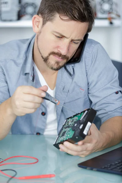 노트북 부품을 분해하는 스마트폰으로 이야기하는 컴퓨터 엔지니어 — 스톡 사진