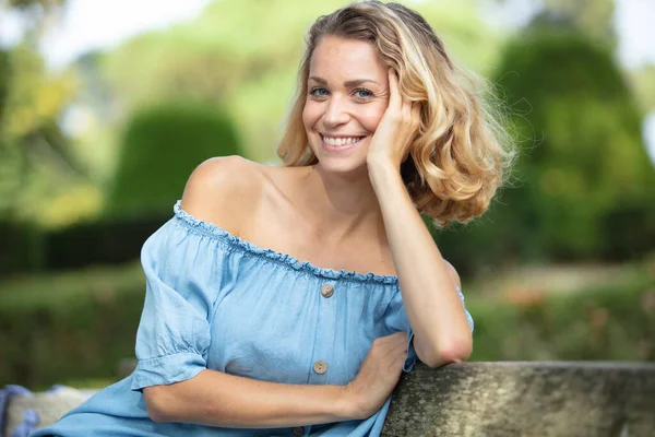 Mujer Rubia Feliz Sentado Aire Libre Pensando —  Fotos de Stock