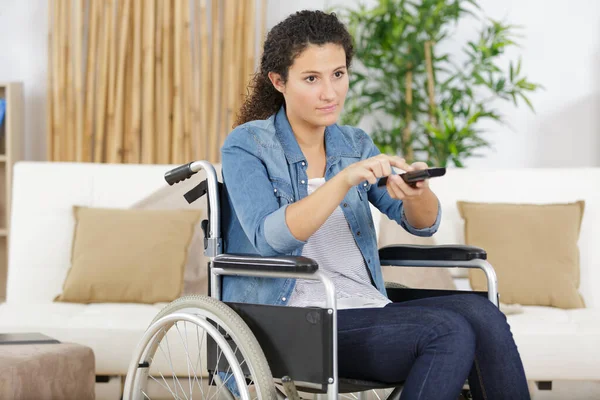 麻痺の女性が車椅子でテレビを見て — ストック写真