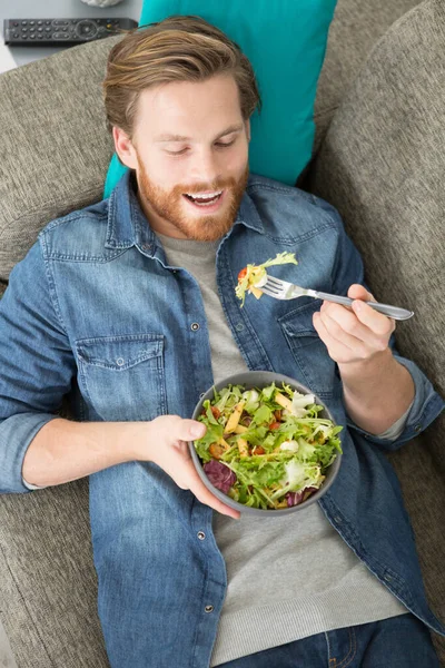 Hombre Comiendo Una Ensalada Saludable Acostado Sofá — Foto de Stock